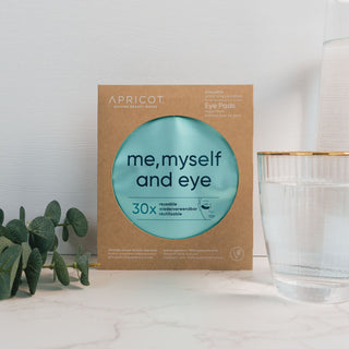 Wieverwendbare Augenpads mit Hyaluron der Marke Apricot Beauty & Healthcare in umweltfreundlicher Kartonverpackung, präsentiert auf einer marmorierten Oberfläche und dekoriert mit Eukalyptus.