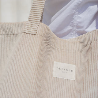 Cordstoff-Tasche Shopper L in der Farbe Beige Delight von De La Mur, Nahaufnahme des beigen Cordstoffes und eingenähtem Marken Label.