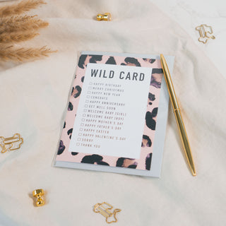 Die universelle Grusskarte "Wild Card" der Marke Typealive, ist ein echter Allrounder für jeden Anlass, präsentiert auf beigen Stoff und goldenen Accessoires.