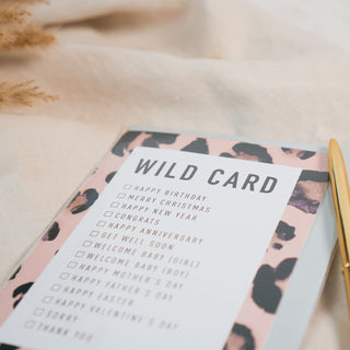 Die universelle Grusskarte "Wild Card" der Marke Typealive, ist ein echter Allrounder für jeden Anlass, präsentiert auf beigen Stoff und goldenen Accessoires.