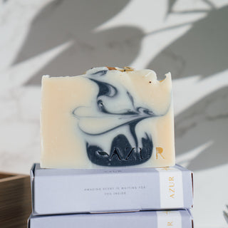 Handgemachte vegane Seife der Sorte Mighty Mint von Azur Natural Bodycare in Nahaufnahme, präsentiert auf gestapelten Verpackungen mit Schatten im Hintergrund.