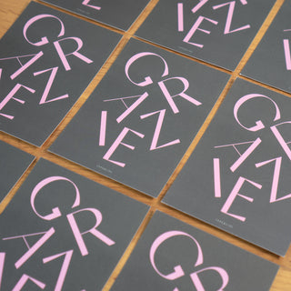 Design-Postkarte mit dem Schriftzug ‘Grazie’ in Pink auf schwarzem Hintergrund, stilvoll und modern arrangiert von Typealive.