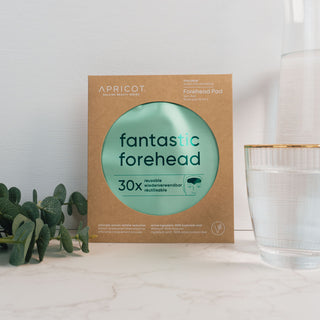 Wieverwendbare Stirnpads mit Hyaluron der Marke Apricot Beauty & Healthcare in umweltfreundlicher Kartonverpackung, präsentiert auf einer marmorierten Oberfläche und dekoriert mit Eukalyptus.