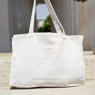 Stofftasche Everyday Bag M in der Farbe Chevron Cream von De La Mur, stehend auf Stufen vor einer hellen Säulenstruktur.