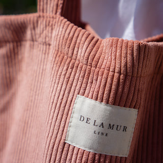 Detailaufnahme der Stofftasche Shopper M in der Farbe Rosy Cord von De La Mur, die den Stoff und das Logo zeigt.