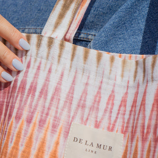 Detailaufnahme der Stofftasche Shopper M in der Farbe Sunset Ikat von De La Mur, die den Stoff und das Logo zeigt.