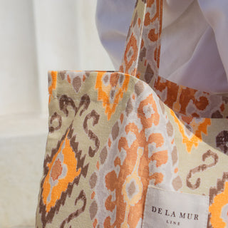 Detailaufnahme der Stofftasche Shopper M in der Farbe Vibrant Ikat von De La Mur, die den Stoff und das Logo zeigt.