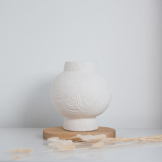 Kleine Vase Athens von der Marke Claet, handgefertigt mit feinen Rillenstrukturen in elegantem Weiß. Modernes und minimalistisches Design, perfekt als Dekorationsstück oder für Trockenblumen, präsentiert mit zarten Pampasgras-Details.