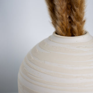 Minimalistische Vase Hera klein, handgefertigt von Claet. Elegantes Design mit sanft gerundeter Form und texturierter Oberfläche perfekt für zeitgenössische Dekorationen oder Trockenblumenarrangements. Gefertigt in hochwertigem, strukturiertem Weiß und Beige.