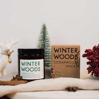 Vegane Duftkerze Winter Woods von Coudre Berlin, präsentiert mit natürlicher Verpackung. Enthält Noten von Zedernholz und Gewürzen, handgegossen in Berlin. Nachhaltig, stilvoll und perfekt für die Winterzeit, dekoriert mit weihnachtlichen Akzenten wie Zimt, roten Beeren und Tannenzweigen.