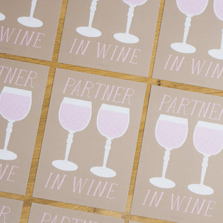 Humorvolle Postkarte mit der Aufschrift ‘Partner in Wine’ und illustrierten Rosé-Weingläsern, in einer stilvollen Tischanordnung, von Typealive.